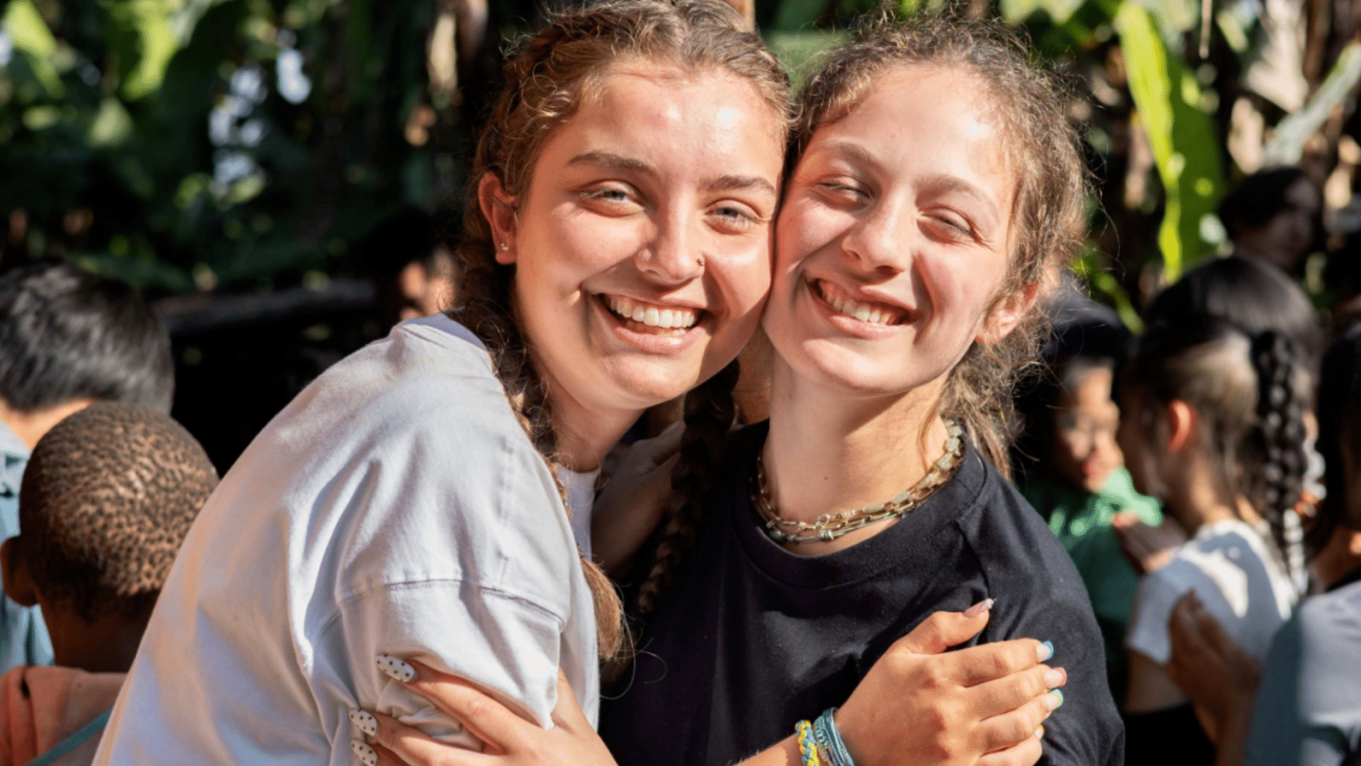 Two happy college-aged students hugging and smiling, representing student success and education goals.
