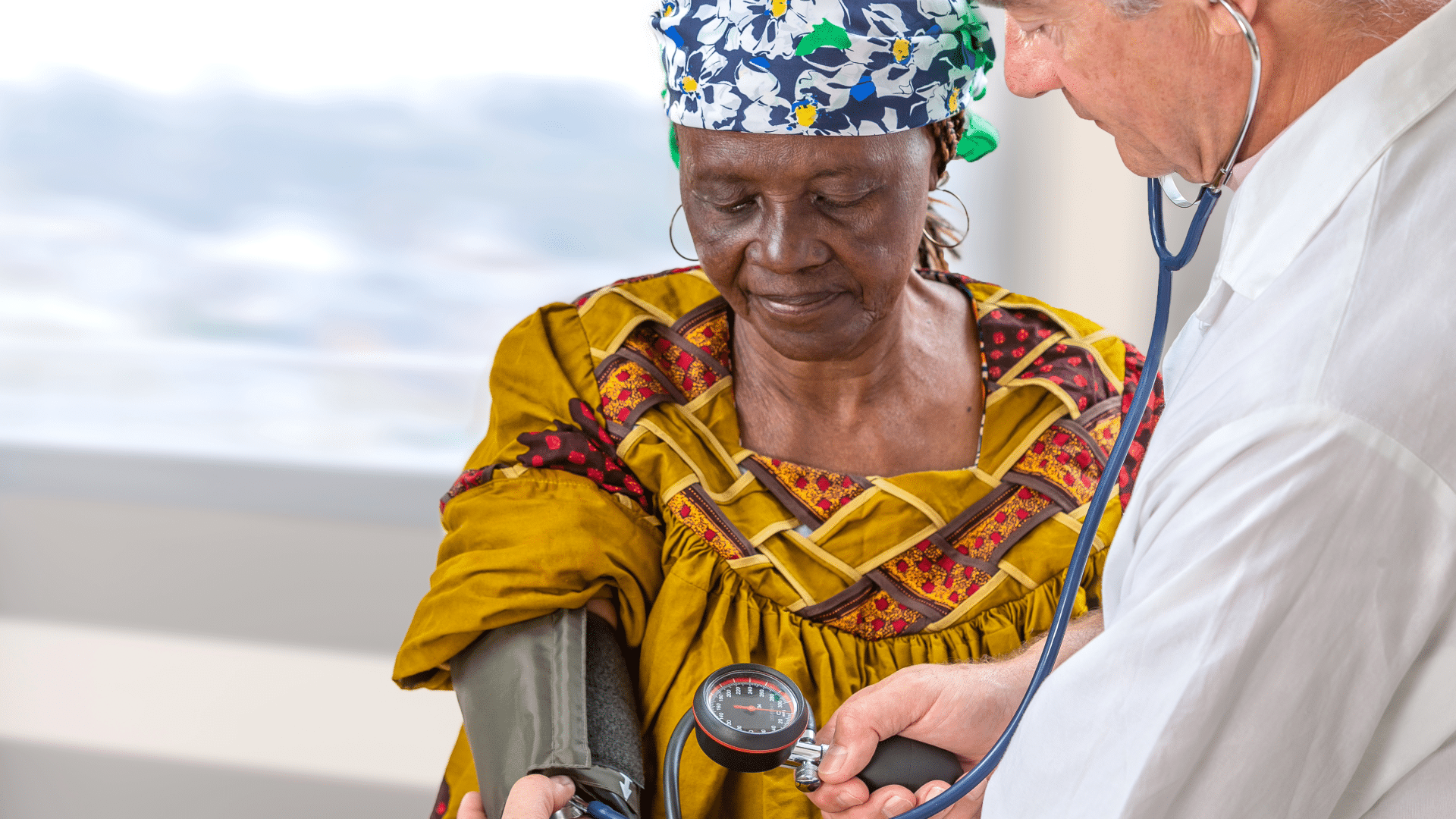 Doctor in white coat take the blood pressure of a woman patient